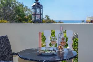 a table with a plate of food and wine glasses at Zefiros by sea in Laganas