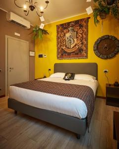 um quarto com uma cama grande numa parede amarela em Binario Magic RistoHotel em Palazzago