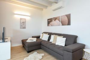 uma sala de estar com um sofá e uma televisão em Caesar Sirmione Luxury Apartment D8 em Sirmione