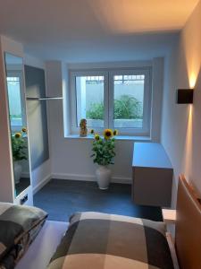 - une chambre avec un lit, une table et deux fenêtres dans l'établissement Schickes Apartment in Düsseldorf- Flehe, à Düsseldorf