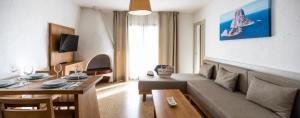 ein Wohnzimmer mit einem Sofa und einem Tisch in der Unterkunft Apartamentos El Moro in Sant Antoni de Portmany