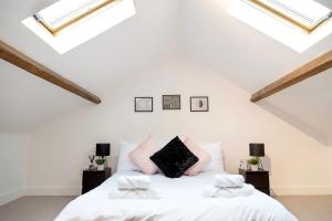 a white bed in a room with skylights at BIG Monthly DIS, Central, Modern, 2bed APT, Sleeps up to 5 in Swindon