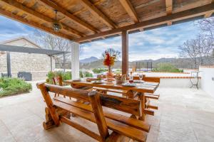 una mesa de madera y un banco en un patio en Villa Biokovska, en Podgora