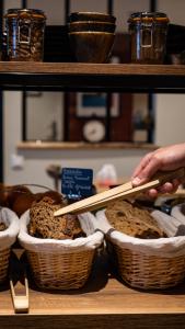 a person holding chopsticks over two baskets of bread at Hôtel Vauban in Le Palais
