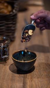 a person holding a spoon with a bowl of food at Hôtel Vauban in Le Palais