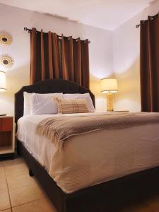 um quarto com uma cama grande e cortinas castanhas em Ocean Village at Combate em Cabo Rojo