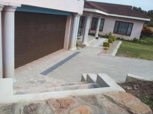 a driveway of a house with a garage at Protea Avenue Margate in Margate