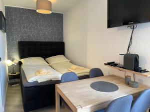 Schlafzimmer mit einem Bett und einem Tisch mit Stühlen in der Unterkunft Apartment Pistenräuber in Winterberg