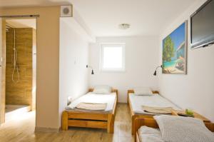 a small room with two beds and a shower at Wind4You in Dąbki