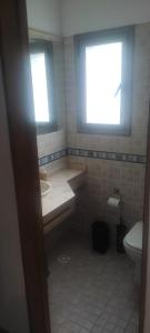 a bathroom with a sink and a toilet and a window at Casa en las sierras in Río Ceballos