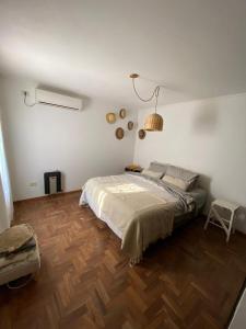 a bedroom with a large bed and a wooden floor at Casa en las sierras in Río Ceballos