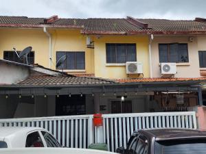une maison avec une clôture blanche devant elle dans l'établissement Tatai Kumang Homestay, à Kuching