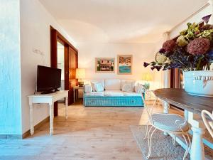 sala de estar con sofá y TV en Villetta A Schiera Caprifogli, en Baja Sardinia