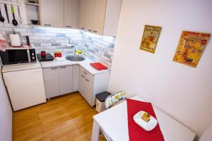 a small kitchen with a table and a sink at Paris Night Private Parking in Niš