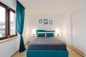 a bedroom with a blue bed and a window at Maison Lorelle Sorrento in Sorrento