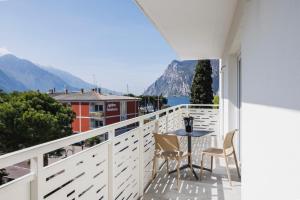 een balkon met een tafel en stoelen en uitzicht bij Lake Side Suites in Riva del Garda