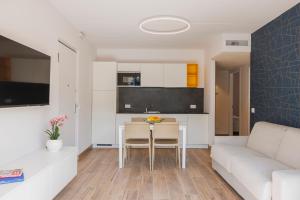 een keuken en een woonkamer met een tafel en een bank bij Lake Side Suites in Riva del Garda