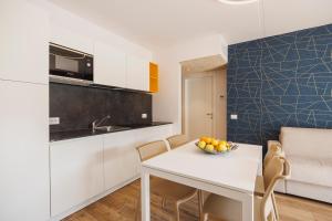 a kitchen with a white table with a bowl of fruit on it at Lake Side Suites in Riva del Garda