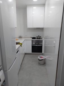cocina blanca con armarios blancos y fogones en Habitación en Madrid, en Madrid
