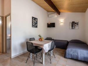 a dining room with a table and a couch at Holiday Home San Antoine by Interhome in LʼÎle-Rousse