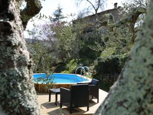 a swimming pool in a garden with a table and chairs at Holiday Home Il Casale by Interhome in Lama