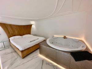 ein Badezimmer mit einer Badewanne neben einem Bett in der Unterkunft JACUZZI SINAGOGA view in Budapest
