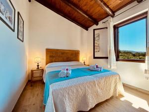1 dormitorio con 1 cama con 2 toallas en Villetta A Schiera Caprifogli, en Baja Sardinia