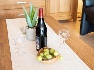 eine Flasche Wein und ein Korb mit Trauben auf dem Tisch in der Unterkunft Apartment Nordwind by Interhome in Norddeich + 41 Fotos