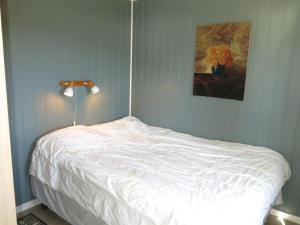 a white bed in a bedroom with a lamp at Holiday Home Øydnablikk by Interhome in Byremo