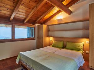 a bedroom with a large bed with green pillows at Holiday Home Casa Susanne by Interhome in Spiazzi Di Caprino