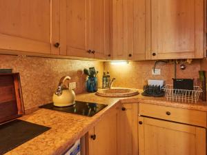a kitchen with wooden cabinets and a sink and a counter top at Holiday Home Casa Susanne by Interhome in Spiazzi Di Caprino
