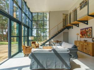 a living room with a couch and a staircase at Holiday Home du bois du Kador by Interhome in Morgat