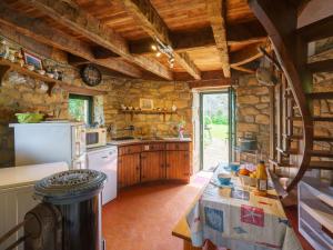 - une cuisine avec des murs en pierre et un réfrigérateur blanc dans l'établissement Holiday Home Le Pigeonnier by Interhome, à Roscanvel