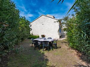 a table and chairs in a yard with a building at Holiday Home Félicité by Interhome in Folelli