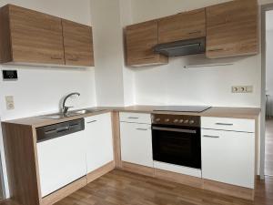 a kitchen with white cabinets and a black oven at Haus HERZOGENBURG - Ferienwohnungen in Herzogenburg