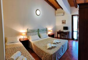 een slaapkamer met twee bedden met witte schoenen erop bij Agriturismo Le Chiuse in Carlentini