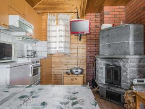 Il comprend une cuisine avec une cheminée et une télévision murale. dans l'établissement Holiday Home Tuomiranta by Interhome, à Pohjavaara