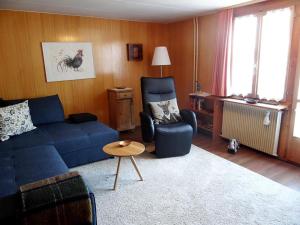 شقة شتايناخر 7 في إنغيلبرغ: غرفة معيشة مع أريكة زرقاء وكرسي
