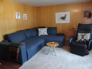 ein Wohnzimmer mit einem blauen Sofa und 2 Stühlen in der Unterkunft Apartment Steinacher 7 by Interhome in Engelberg