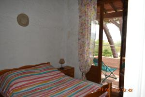 Schlafzimmer mit einem Bett und einer Glasschiebetür in der Unterkunft Maison de 4 chambres de front de mer Corse-du-Sud in Appietto