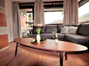 a living room with a table and a couch at Apartment Haus Achenstrasse-5 by Interhome in Bad Hofgastein