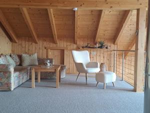 a living room with a couch and a chair and a table at Chalet Dolzer by Interhome in Hochrindl
