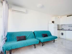 ル・バルカレスにあるStudio Vistaéro-7 by Interhomeのキッチン付きの客室で、青いソファが備わります。