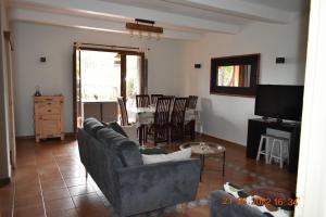 ein Wohnzimmer mit einem Sofa, einem TV und einem Tisch in der Unterkunft Maison de 4 chambres de front de mer Corse-du-Sud in Appietto