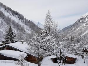 une maison recouverte de neige avec des arbres et des montagnes dans l'établissement Apartment Chalet Le Tour by Interhome, à Chamonix-Mont-Blanc