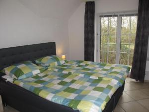 a bedroom with a bed with a checkered blanket at Apartment Gollwitzer Park - Insel Poel-3 by Interhome in Gollwitz