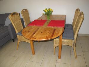 a wooden table with chairs and a vase of flowers on it at Apartment Gollwitzer Park - Insel Poel-2 by Interhome in Gollwitz