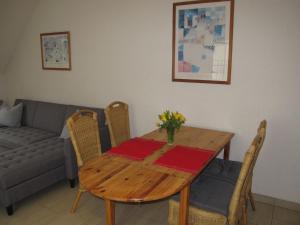 a wooden table with chairs and a couch at Apartment Gollwitzer Park - Insel Poel-2 by Interhome in Gollwitz