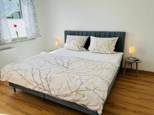 ein Schlafzimmer mit einem Bett mit einer Baumbettdecke in der Unterkunft Ferienwohnung am Eberbach in Stadtoldendorf