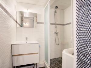a white bathroom with a sink and a shower at Apartment Les Villageoises-2 by Interhome in Le Barcarès